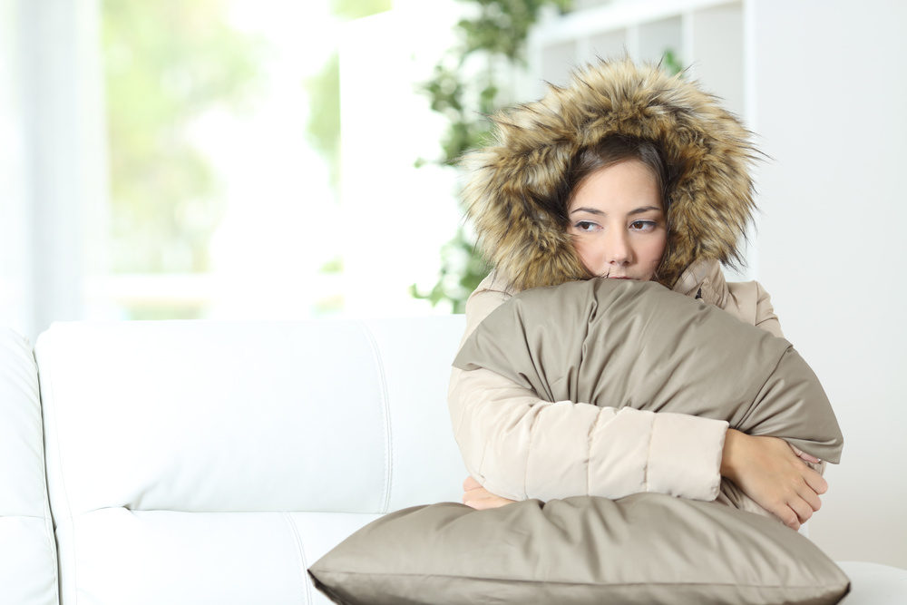 Woman warmly clothed in a cold home furnace installation company
